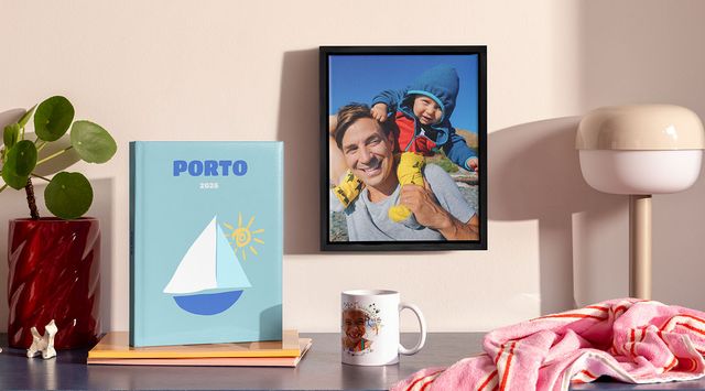 Coleção de produtos fotográficos personalizados numa estante, com um álbum de fotos, uma impressão emoldurada e uma caneca.