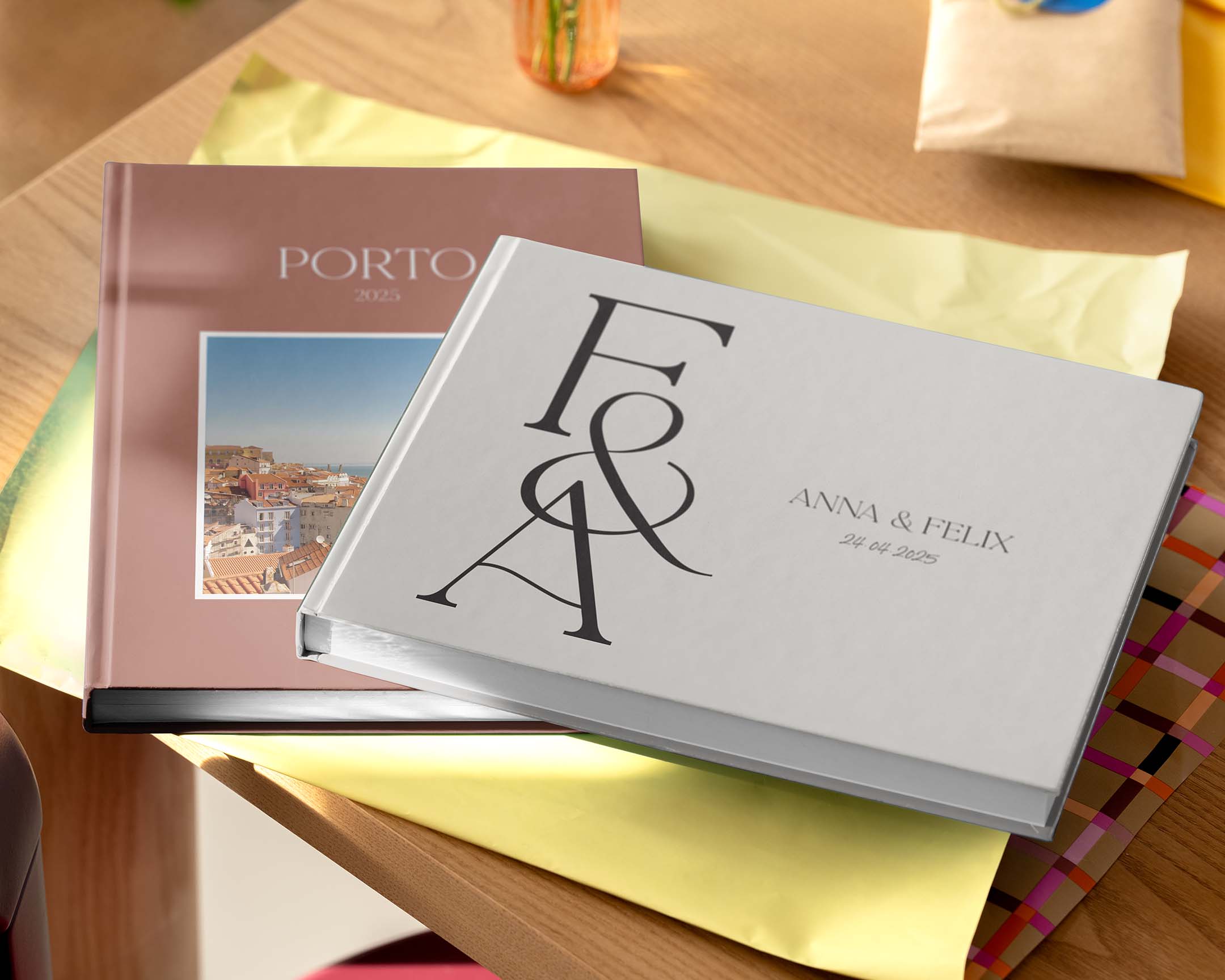 Dois álbuns de fotos personalizados numa mesa, em tamanhos e designs diferentes.