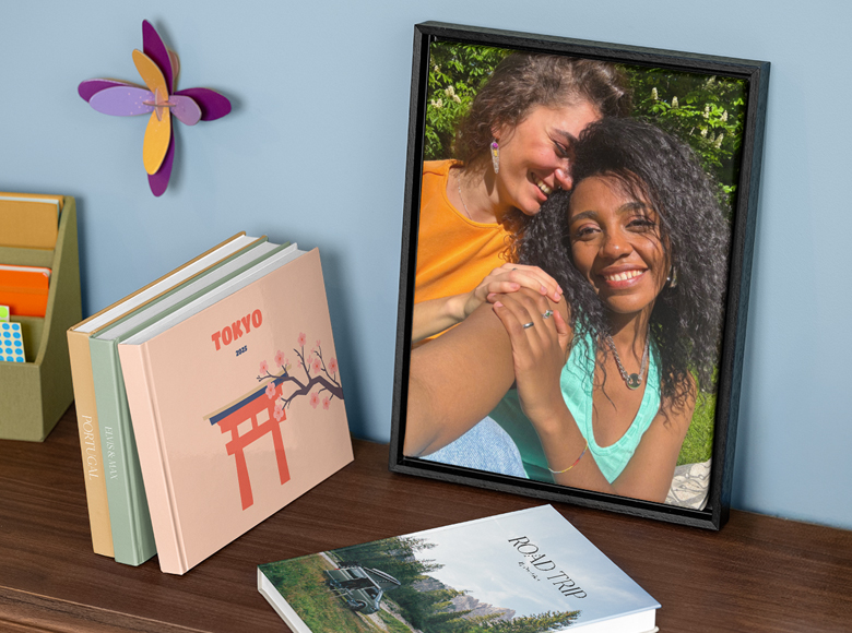 Uma peça de decoração de parede personalizada e vários álbuns de fotos personalizados numa prateleira