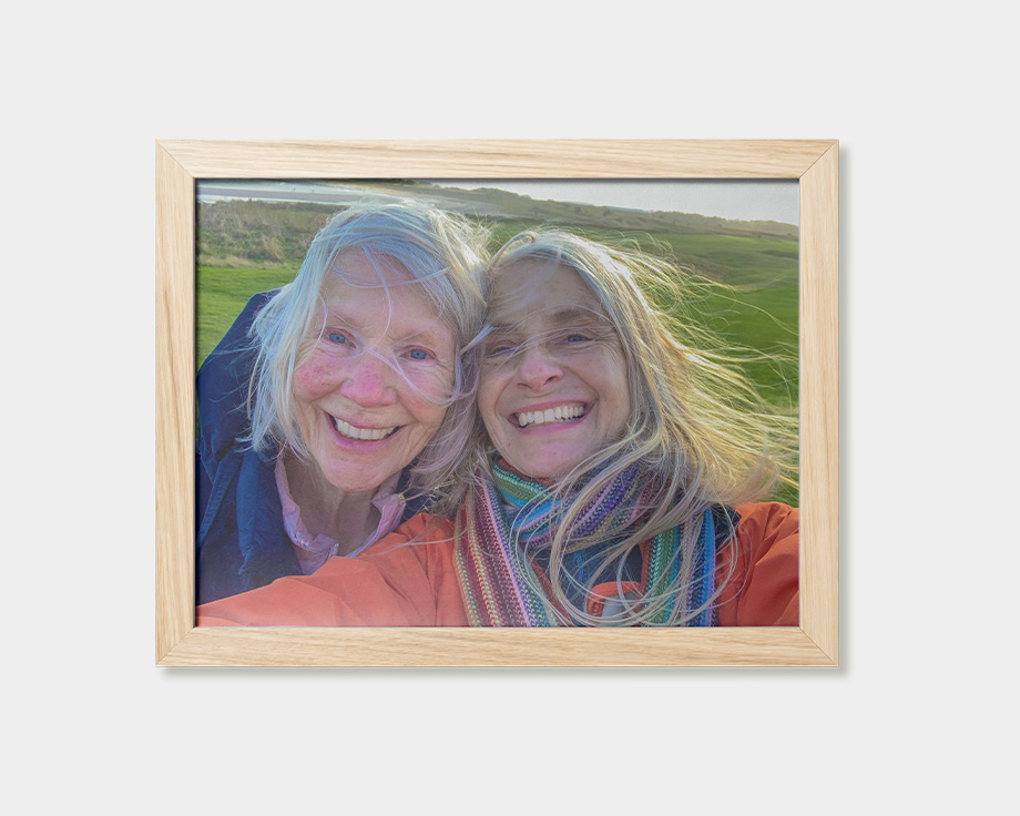 Um póster emoldurado com a imagem de duas mulheres a sorrir