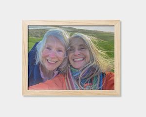 Um póster emoldurado com a imagem de duas mulheres a sorrir