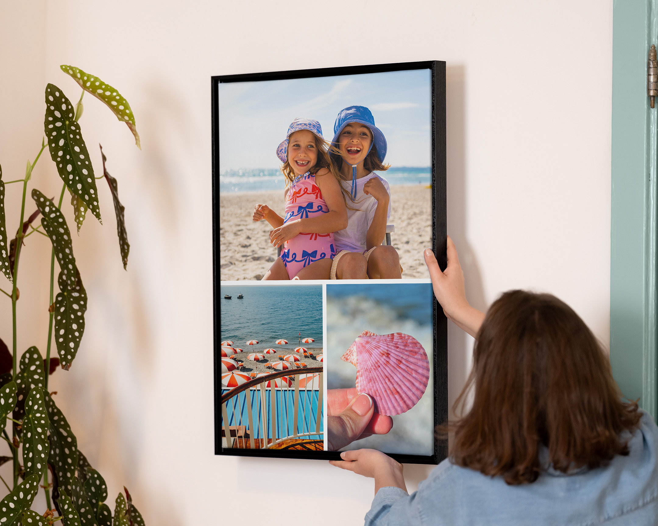 Pessoa a pendurar uma colagem impressa e emoldurada