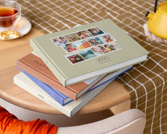 Pilha de álbuns de fotos personalizados numa mesa