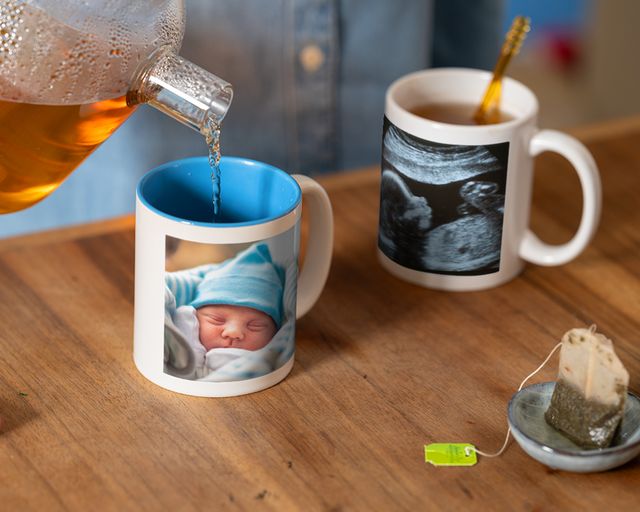Chá servido numa caneca personalizada com a fotografia de um recém-nascido ao lado de uma caneca com a sua ecografia.