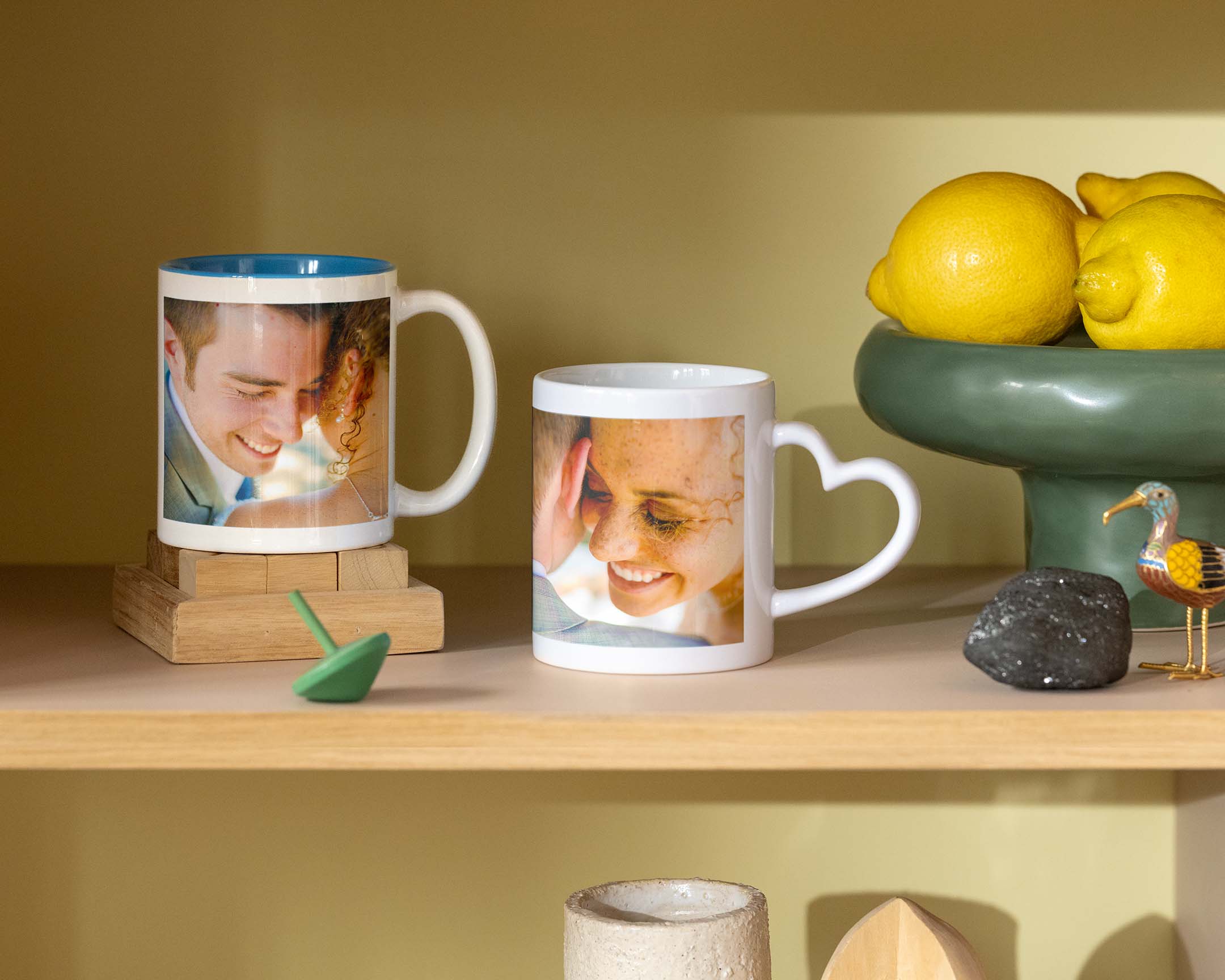 Duas canecas personalizadas com fotos de casamento, uma com uma pega em forma de coração.